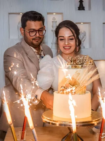 A celebratory moment as the couple cuts their anniversary cake, surrounded by the warm glow of sparklers. This shot captures the magic and excitement of their milestone.