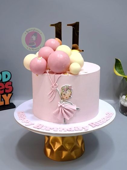 A pretty pink ballerina cake, decorated with edible chocolate spheres that look like balloons.
