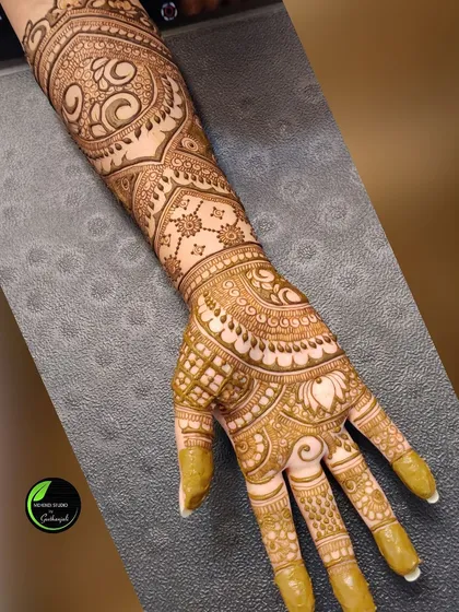 A single arm shot showing the rich, dark stain of a complex bridal design.