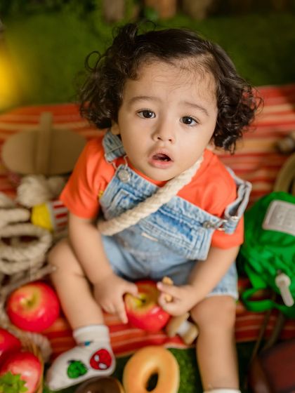 A close-up of the adorable baby with curly hair during the fantasy picnic shoot.