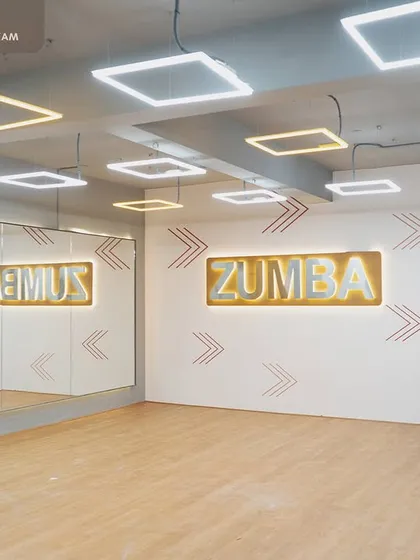 This dedicated Zumba area at Robur Fitness Hub is designed for high-energy group classes. We used bright, illuminated signage, full-length mirrors to enhance the sense of space, and modern square lighting fixtures to create an inspiring and functional studio environment.