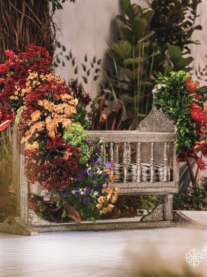 The traditional 'thottil' or cradle, beautifully adorned with flowers, sits at the heart of the indoor orchard. This is where the baby's naming ceremony takes place, surrounded by symbols of life and abundance.
