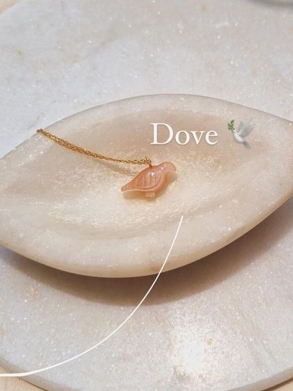The 'Dóve' pendant, a symbol of peace and good fortune.
