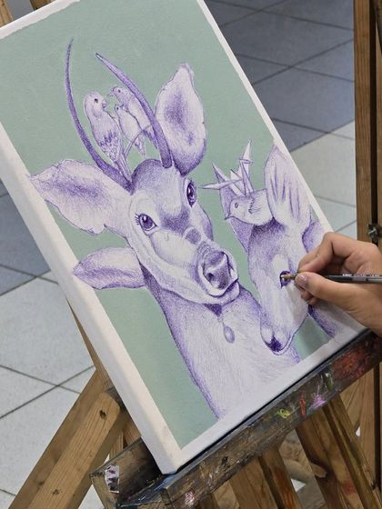 This shot captures the artist's perspective, looking over her shoulder as she meticulously works on her detailed ballpoint pen drawing.