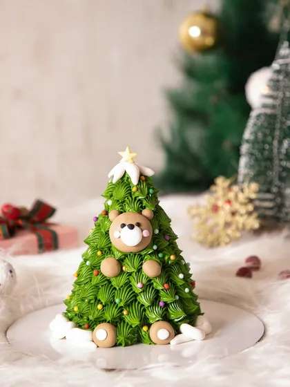 Oh, Christmas tree! This adorable cake is shaped like a Christmas tree and features a cute little bear peeking out from the branches.