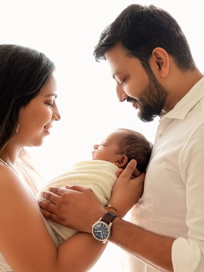 A classic family pose, with the father holding the baby as the mother looks on lovingly. Timeless and full of emotion.