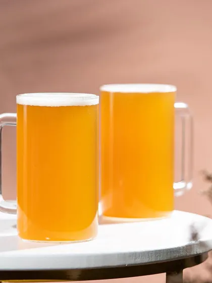 A simple and elegant product shot of the Borosil mugs against a soft pink background, showcasing their clean lines and modern aesthetic.