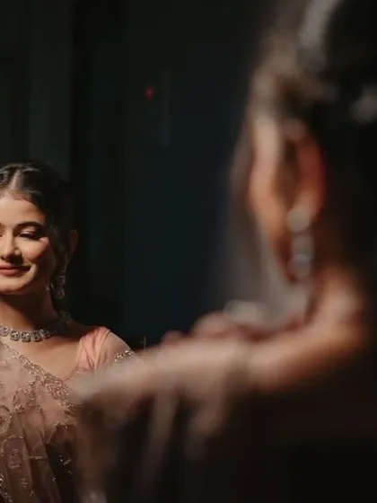 A Roka ceremony look captured in a mirror. The makeup is soft and romantic, perfect for this intimate celebration.