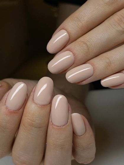 A sophisticated beige-nude manicure on oval-shaped nails. This versatile and understated color is the perfect everyday neutral.