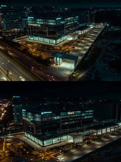 A dramatic night-time aerial shot of the Collins Aerospace building in Bengaluru. Our low-light drone photography highlights the building's modern design and illumination against the city skyline.