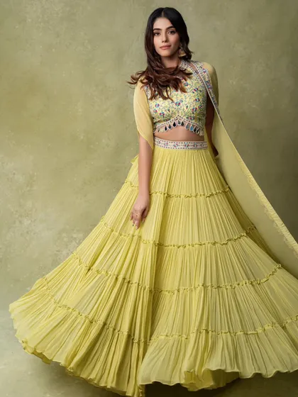 A full-length shot of a tiered yellow lehenga in motion. This dynamic image is perfect for a website banner or social media, as it's eye-catching and shows the garment's playful character.