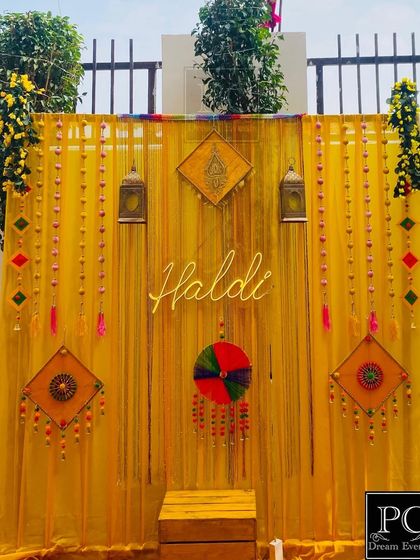 A bright and sunny Haldi backdrop with yellow drapes, a neon sign, and traditional Rajasthani decorative pieces. This setup is perfect for creating a festive and photogenic corner.
