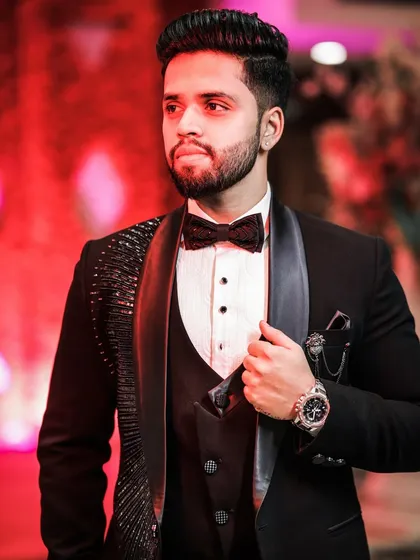A stylish portrait of the groom, with dramatic red lighting in the background. This photo highlights his modern style and confident presence.