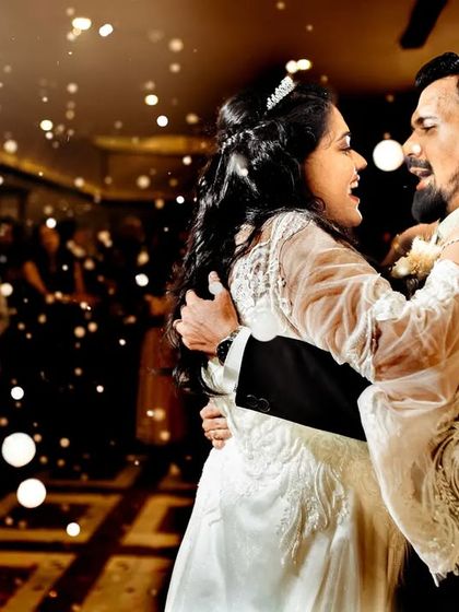 A beautiful first dance moment, with the couple lost in their own world, surrounded by bubbles and the warm lights of the reception.