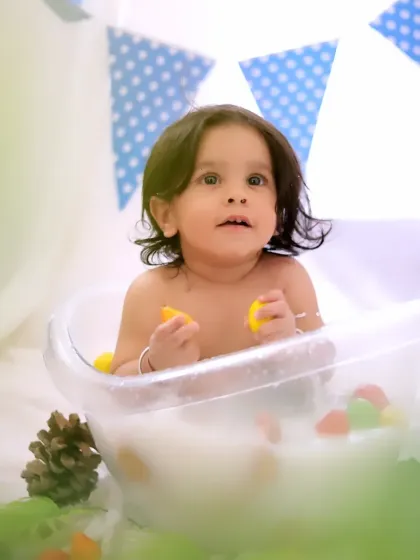 A simple and sweet tub splash session. The clean, bright setup with blue accents and rubber ducks makes for classic and joyful baby photos.