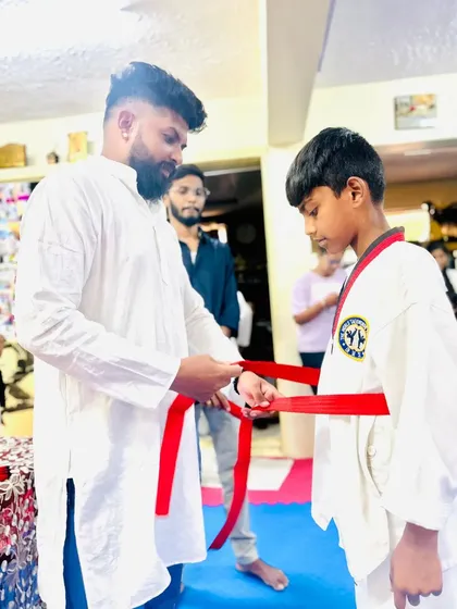 Tying the red belt, a significant achievement.