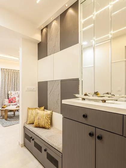 A closer look at the entryway unit. The combination of a comfortable seating nook, a console table, and mirror panels makes this a highly practical and stylish space.
