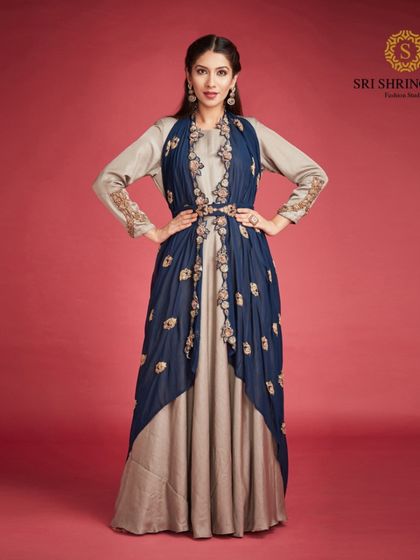 Look stylish and walk with confidence in our Indo-Western dress. This layered gown with an embroidered jacket is a perfect fusion of comfort and elegance.