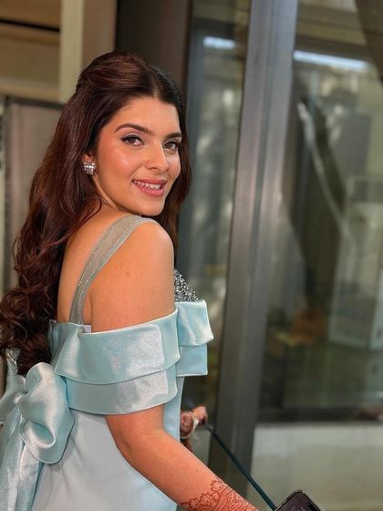 A candid, over-the-shoulder shot of the client. Her soft waves and simple half-up style look effortlessly beautiful.