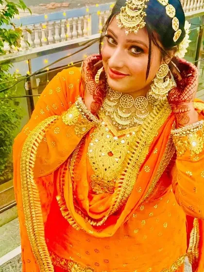 A vibrant look perfect for a Haldi or Mehendi ceremony. I provided the complete package for this client, including the bright orange sharara suit, floral-style jewelry, and fresh, glowing makeup.