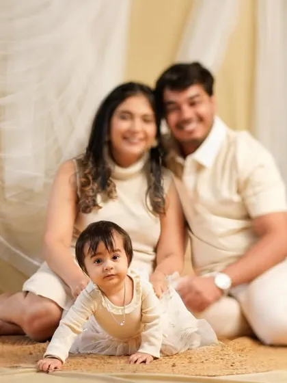A happy baby crawling towards the camera while her parents watch with love. We capture your child's milestones, like crawling, within the beautiful context of a family portrait.
