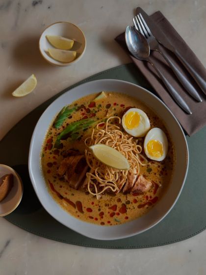 A top-down view of the Khao Suey, ready to be enjoyed with a squeeze of lime.