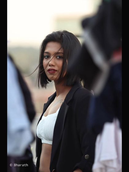 This shot captures a fleeting glance, framed by blurred objects that create a sense of intimacy and intrigue.