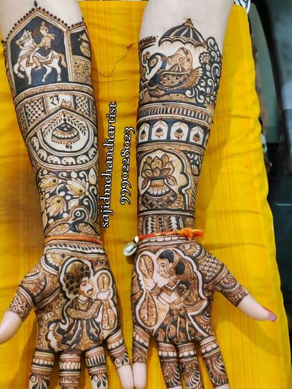 Here, the bride and groom are depicted in a traditional varmala (garland exchange) pose. The forearms are adorned with a baraat scene on one arm and a doli on the other, creating a complete wedding narrative.