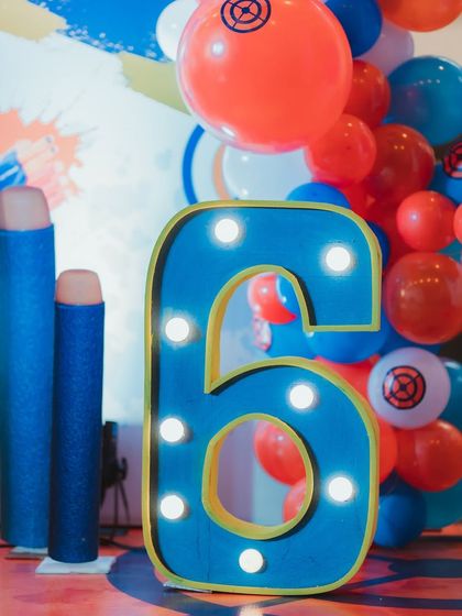 A close-up of the custom light-up number '6' and oversized Nerf dart props, adding a fun and thematic detail to the decor.