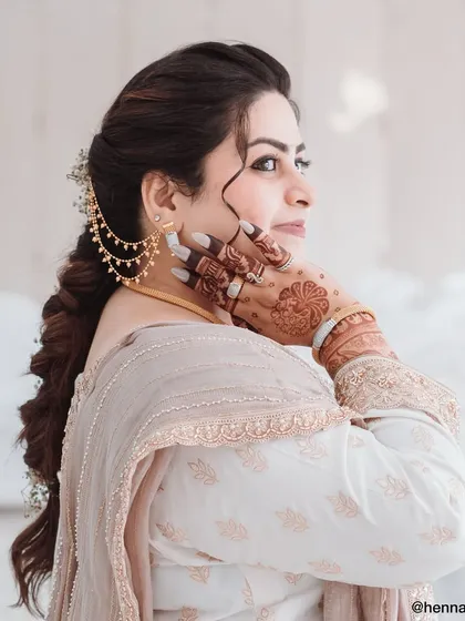 A stunning portrait of a client on her special day. The back-of-hand mehendi complements her traditional attire and elegant hairstyle perfectly.