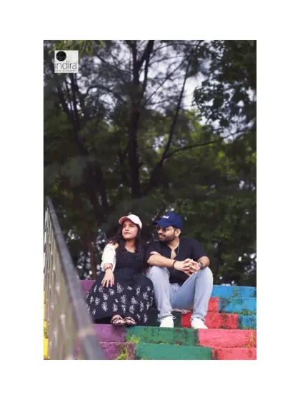 A fun, casual shot of the couple sitting on colorful steps, showing a more playful side to their outdoor maternity photoshoot.