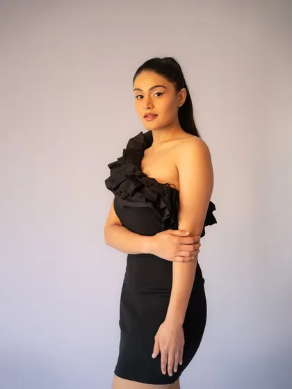 A simple and elegant pose. The sleek ponytail and clean makeup create a polished look that is both modern and timeless.