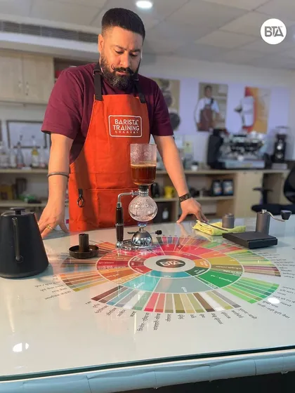 A wide shot of the Syphon brewing setup on our flavor wheel table. We love showing our students the theater of different brewing methods.