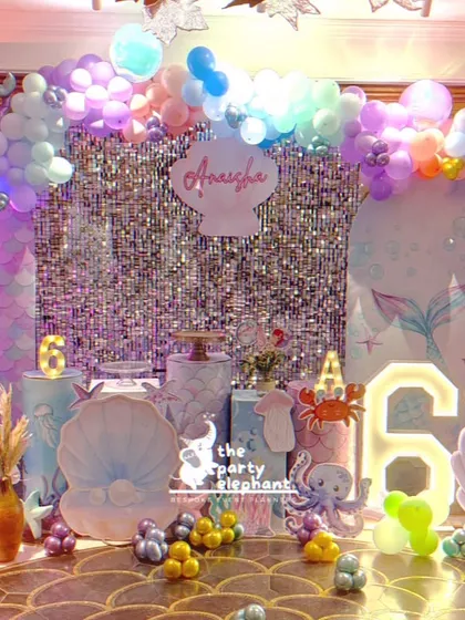 I dove deep into creativity for this 'mermazing' 6th birthday party. The complete underwater scene includes two distinct photo backdrops, marquee numbers, character cutouts like Ariel and her friends, and iridescent balloon garlands to mimic ocean bubbles.