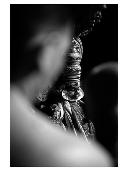 A creatively framed, artistic shot of a Kathakali performer in black and white, adding a layer of mystery and drama to the image.