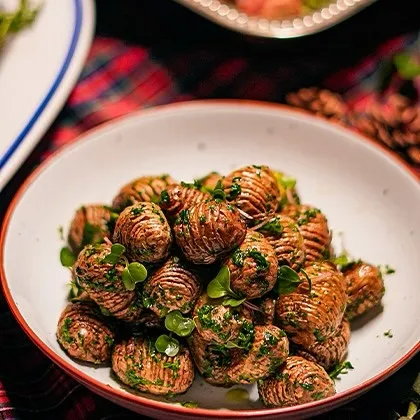 A festive dish of Hasselback potatoes, part of our holiday menu. These are perfect for sharing and celebrating during the festive season, from Christmas to Boxing Day.