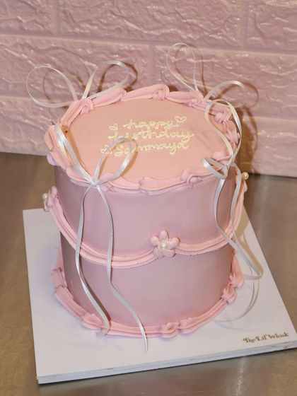 The full view of this sophisticated two-tiered pink cake, proving that milestone birthdays can be both cute and classy.