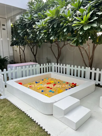 A closer look at our white portable sandpit, complete with colorful toys. The padded vinyl frame and included ground mat make it a safe and mess-free option for any location.