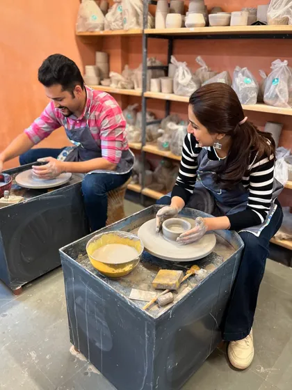 A perfect date to unwind together. This couple is finding their peace side-by-side at the potter's wheel, sharing a moment of calm and creativity.