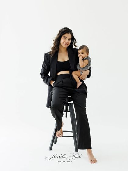 This full-length view of the modern mother-daughter portrait showcases a confident and loving pose, blending style with tender connection.