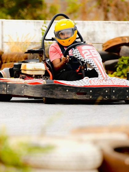 A driver focused on the track ahead, navigating past the tire barriers. Every lap is a chance to improve your skill.