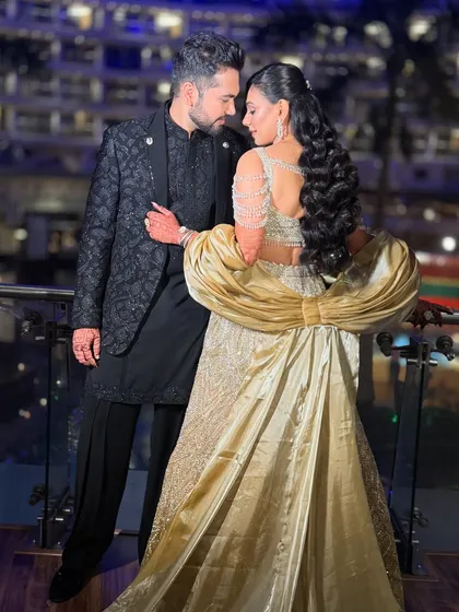 A stunning shot of the couple against the city lights. The bride's dramatic outfit with the large bow is perfectly complemented by her glamorous makeup.