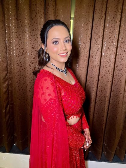 Sangeet-ready in the dreamiest red. For Archana, we went with dewy skin, a soft smoky eye, and a touch of gloss.