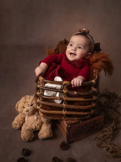 A happy gurgle from the baby sister. Coordinating sibling shoots allows me to capture both individual portraits and their shared moments together.