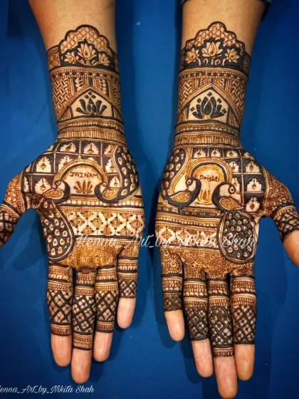 A client-requested design featuring bold peacock motifs. The peacocks are personalized with names, and the rest of the hand is filled with traditional jaali (net) and floral patterns.