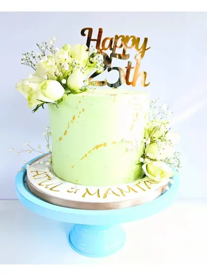 Celebrating 25 years of love is a huge milestone. This anniversary cake, with its soft pastel green frosting and fresh white flowers, was designed to be as beautiful as the journey it represents.