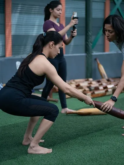 Form is everything. Here, one of our coaches provides personalized guidance during a women's session. We focus on teaching you the right way to move to build strength safely and prevent injury, ensuring you get the most out of every workout.
