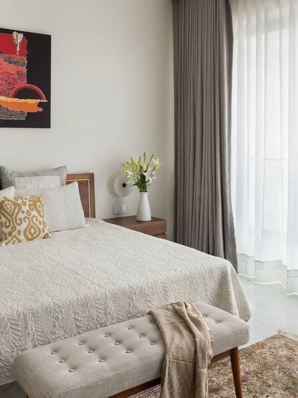 This bedroom in our Bayview project is designed to be bright and airy. A simple bed frame and a comfortable bench are paired with a bold piece of art, creating a space that is both functional and visually interesting.