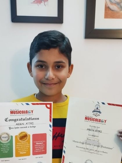 Arjun proudly holds up his certificates after successfully completing his Guitar Garage course. We believe in celebrating every milestone.