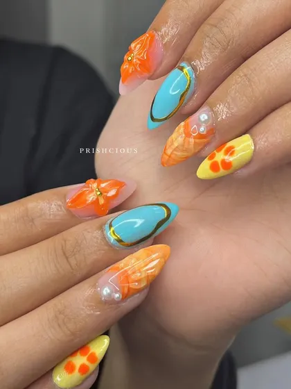 Another look at these mermaid-vibe vacation nails. The combination of turquoise, orange, and yellow with gold chrome accents is just so dreamy.